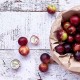 Frutti freschi di Camu Camu (Myrciaria dubia) raccolti in sacchetto di carta su superficie in legno chiaro, bacca amazzonica utilizzata nei prodotti naturali Erbologica Amazonas Andes.