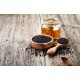 Semi di Cumino Nero (Nigella sativa) con olio naturale su tavolo in legno