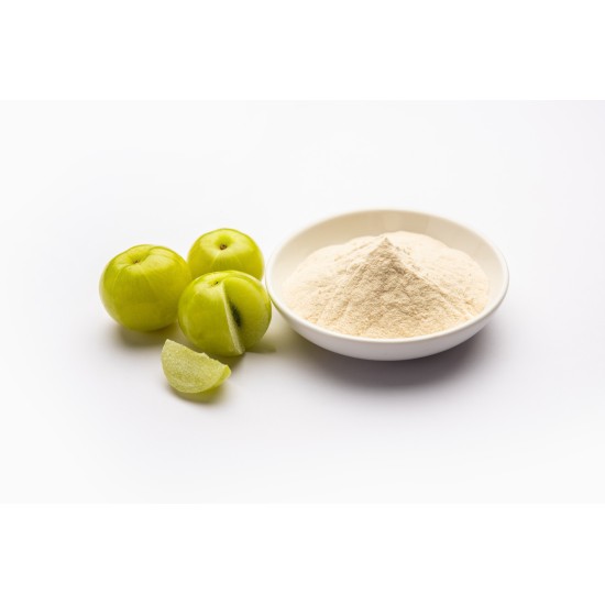 Ciotola con polvere di Amla naturale accanto a frutti freschi di Emblica su sfondo chiaro.