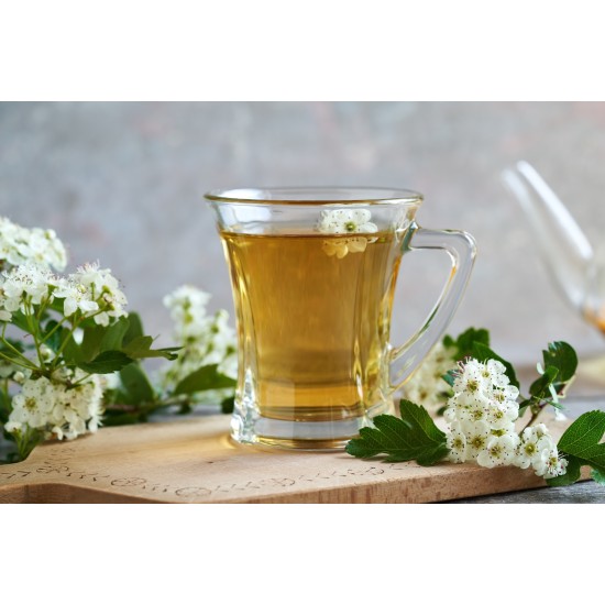 Tisana di Biancospino Erbologica Amazonas Andes Infuso di Fiori e Foglie Tazza di vetro con tisana di Biancospino Erbologica Amazonas Andes, infuso dorato circondato da fiori e foglie di biancospino.