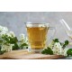 Tisana di Biancospino Erbologica Amazonas Andes Infuso di Fiori e Foglie Tazza di vetro con tisana di Biancospino Erbologica Amazonas Andes, infuso dorato circondato da fiori e foglie di biancospino.